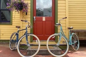 Two bicycles parked in front of a yellow building with a red door. - Petite Maison: Hip & Historic (Telluride)