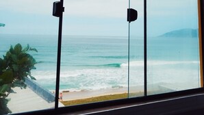 A large window with a view of the ocean and a distant mountain. - Graffi Beach Houses (Florianópolis)