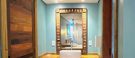 Une salle de bain avec un meuble-lavabo en bois, un miroir et un lavabo.