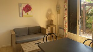 A cozy room with a sofa, a table, a lamp, and a window with a curtain.