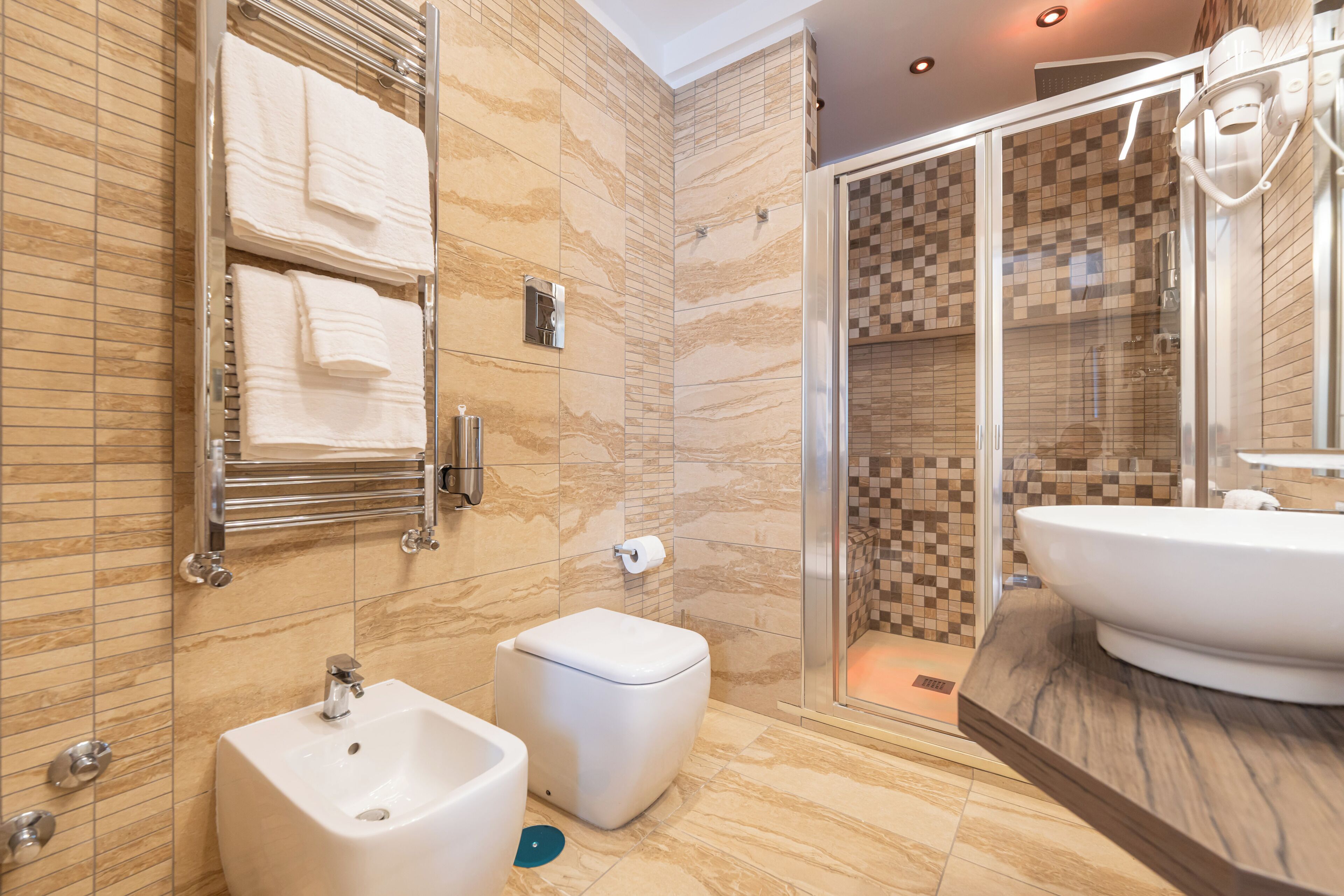 A modern bathroom with a large sink, a toilet, and a shower area.