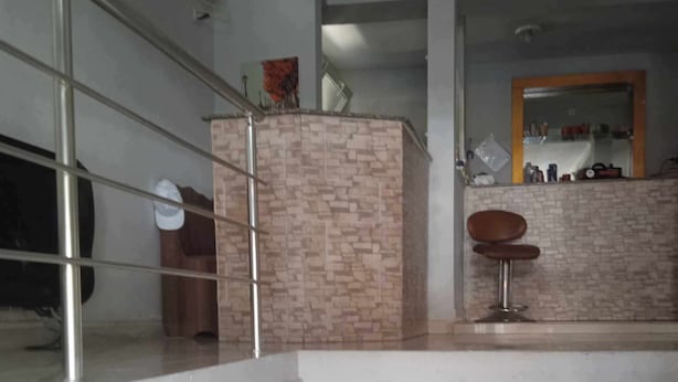 A staircase leading to a bar area with a stone wall and a wooden chair. - sunshine (Batumi)