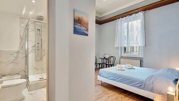 Suite Confort, vistas a la ciudad | Baño | Ducha, artículos de higiene personal gratuitos y secador de pelo