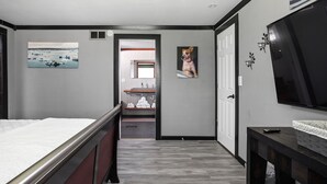 A modern bedroom with a bed, a TV, and a painting on the wall. - Sleeps 10/Batting Cage/Theater! (Westfield)