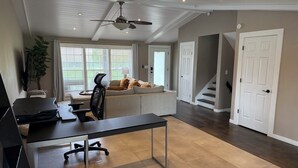 A spacious living area with a sofa, a desk, and a ceiling fan. - Sleeps 10/Batting Cage/Theater! (Westfield)