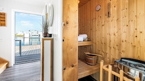 Et træsmed sauna med udsigt til et bassin udefra.