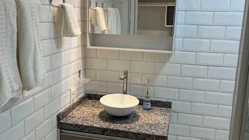 Chuveiro, secador de cabelo, toalhas de banho, papel higiênico