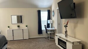A bedroom with a bed, a desk, a TV, and a dresser. - 5BR Home w/ Game & Fitness Rooms 15 Mins to Ft Benning. (Phenix City)