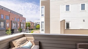 A balcony with wicker furniture and a view of adjacent buildings. - Luxury Downtown Townhome w/ Private Garage Unit 16 (Cleveland)