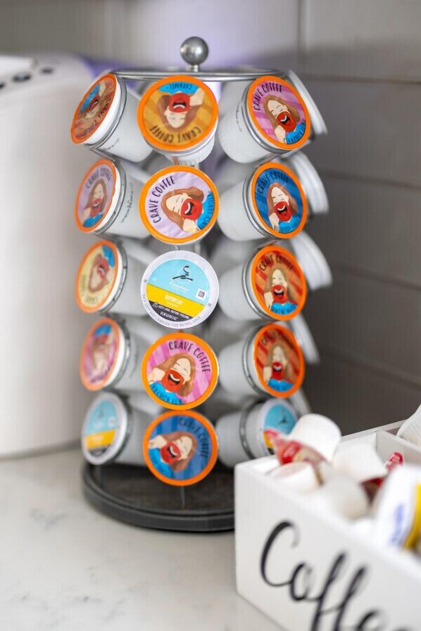 Un dispensador de café con varios compartimentos, cada uno con la etiqueta 'Crave Coffee' y personajes de caricatura.