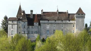 A large, historic stone castle with multiple towers and a fortified appearance.