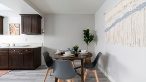 A modern dining area with a round table, four chairs, and a small plant. - DT Alhambra 2Br/2Ba with King bed + EV Charger (Alhambra)