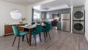 Eine moderne Küche mit grauen Schränken, Edelstahlgeräten und einem eingebauten Backofen.