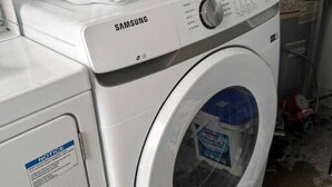 Lavadora Samsung de carga frontal en un cuarto de servicio.