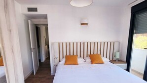Ein geräumiges Schlafzimmer mit einem großen Bett, einem Holzkopfende und einer Deckenleuchte.