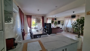 Un espacio habitable amplio con una mesa de comedor, sofá y una encimera de cocina.