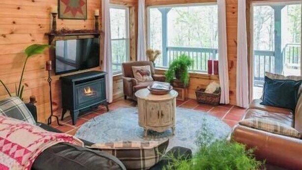 Ein gemütliches Cabin-Interieur mit Kamin, Fernseher und einer komfortablen Sitzecke.