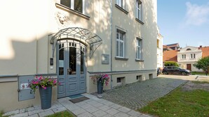 A building with a grey door, a lion head sculpture, and a cobblestone path. - Bryza by Grand Apartments (Sopot)