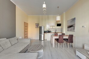 Un soggiorno moderno con un divano, un tavolino rotondo e un'area pranzo con sedie e tavolo.