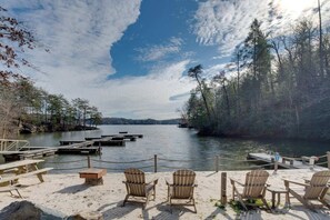 Relax on the lakeside dock, surrounded by a forested area and comfortable seating.