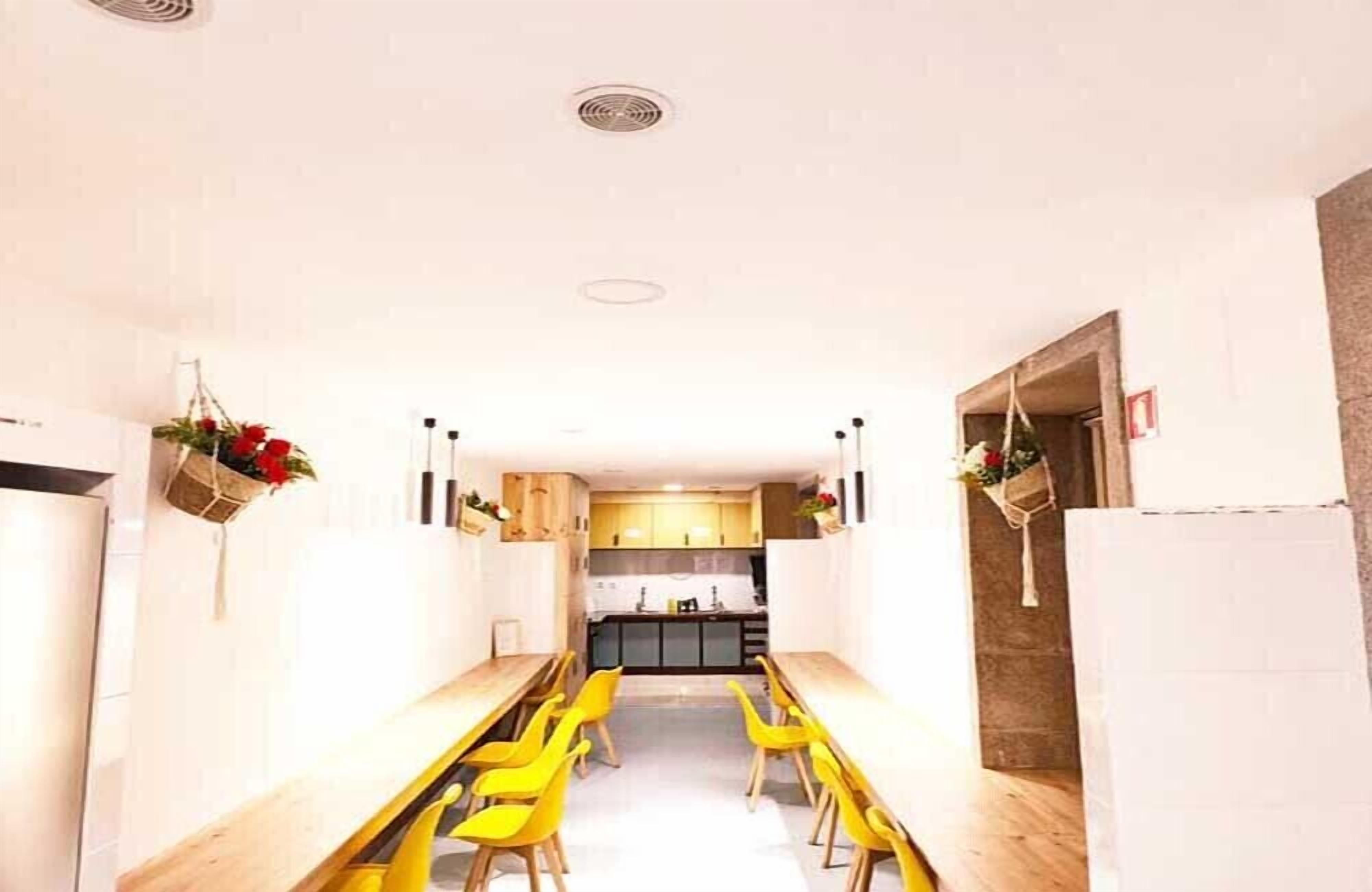 A modern kitchen with white cabinets, a central island, and yellow chairs.