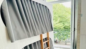 A room with a bunk bed, a wooden ladder, and a view of greenery outside. - Fantasy Hostel Porto (Porto)