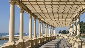 A covered walkway with columns and a view of the sea. - Fantasy Hostel Porto (Porto)