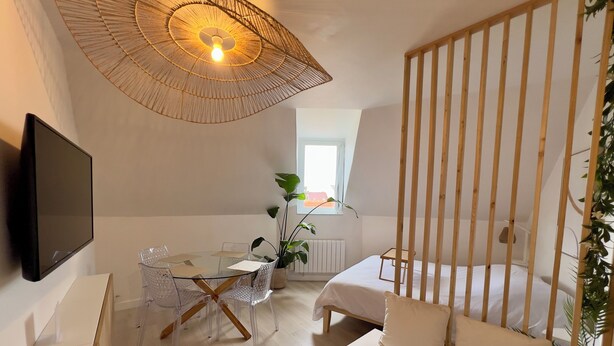 Une chambre à coucher moderne avec un lit, une table de chevet et un téléviseur fixé au mur.