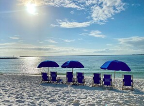 A beach with sun umbrellas and lounge chairs. - 3-bedroom condo on the 9th floor of EG with superb views of the gulf and harbor. (Destin)