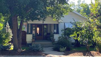 A single-story house with a front porch, a mailbox, and a small garden area.