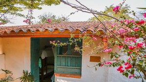 A rustic building with a tiled roof, a doorway, and a small window. - El Cogollo (Barichara)
