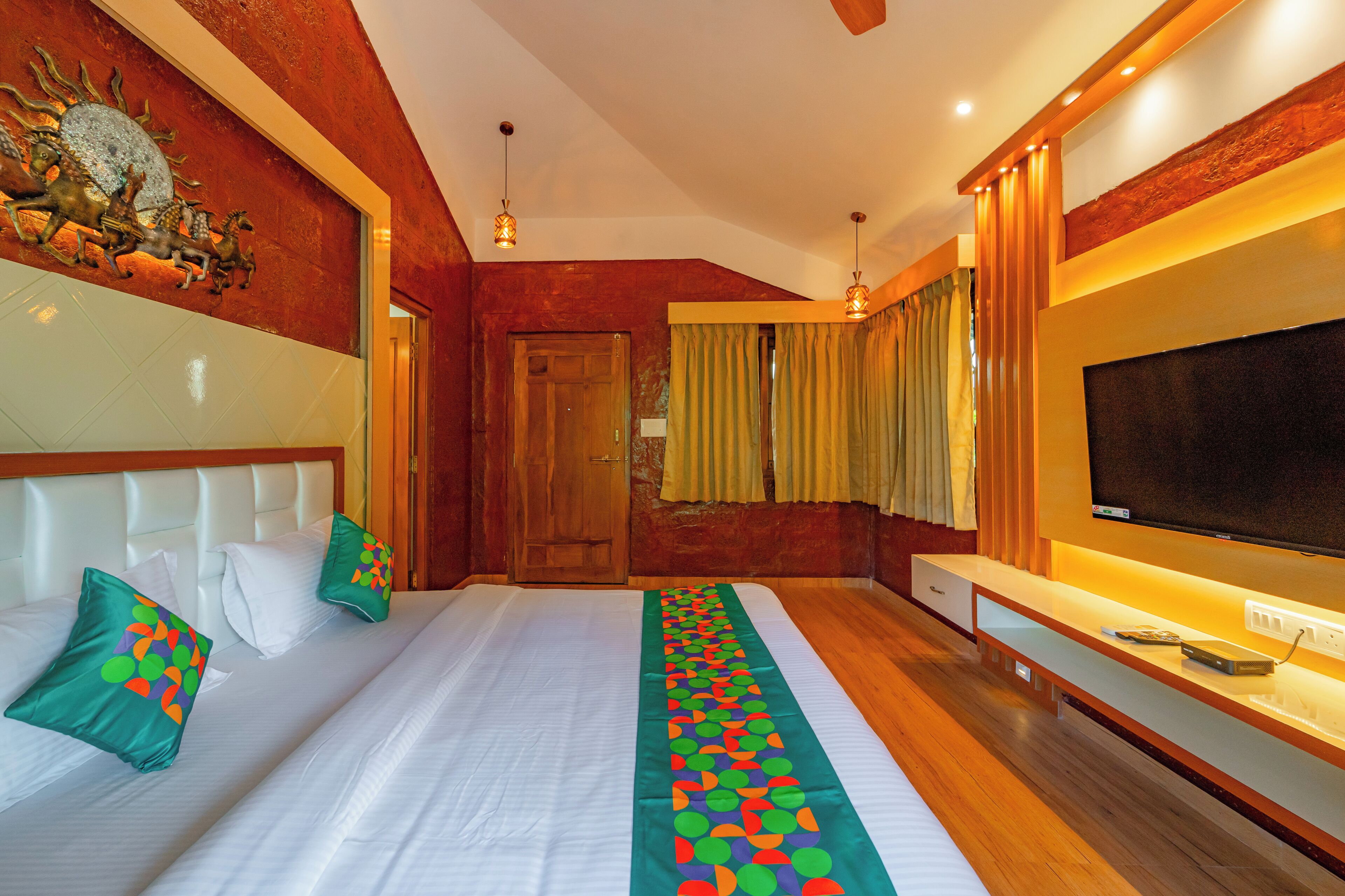 Une chambre d’hôtel avec un grand lit, une télévision, un plancher en bois et un élément décoratif mural.