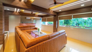 Una sala de estar moderna con un sofá seccional, una mesa de centro y un ventilador de techo.
