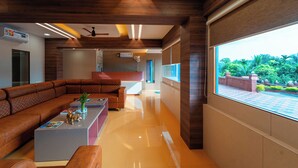Una sala de estar moderna con un sofá modular, una mesa de centro y un ventanal con vistas a espacios verdes.
