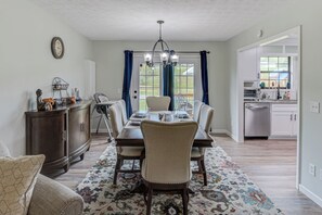 Enjoy meals with family and friends in this spacious dining area, complete with a large table and matching chairs.