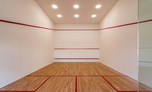 Ein Squashplatz mit Holzboden und roten Spielfeldmarkierungen.