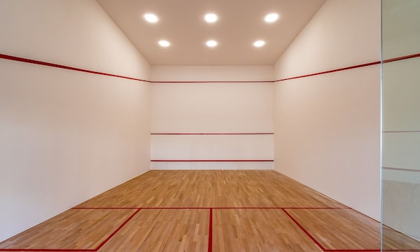 A squash court with wooden flooring and red boundary lines. - Lindos apts c piscina no Setor Oeste IDV (Goiânia)