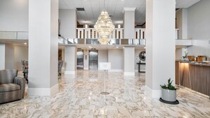A spacious lobby with a marble floor, a chandelier, and a reception desk. - Palm Beach Island Seasonal Rental 6 month required 
Oceanfront 2 bed 2 bath  (Palm Beach)