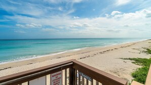 A beach with a lifeguard warning sign, a wooden deck, and a clear view of the ocean. - Palm Beach Island Seasonal Rental 6 month required 
Oceanfront 2 bed 2 bath  (Palm Beach)