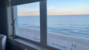 A view of a beach through a window, with a clear sky and calm sea. - Palm Beach Island Seasonal Rental 6 month required 
Oceanfront 2 bed 2 bath  (Palm Beach)