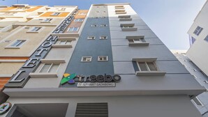 A multi-story building with a sign reading "Hotel de Alphabet Gachibowli" and the logo "reeboo". - Treebo De Alphabet Gachibowli (Hyderabad)
