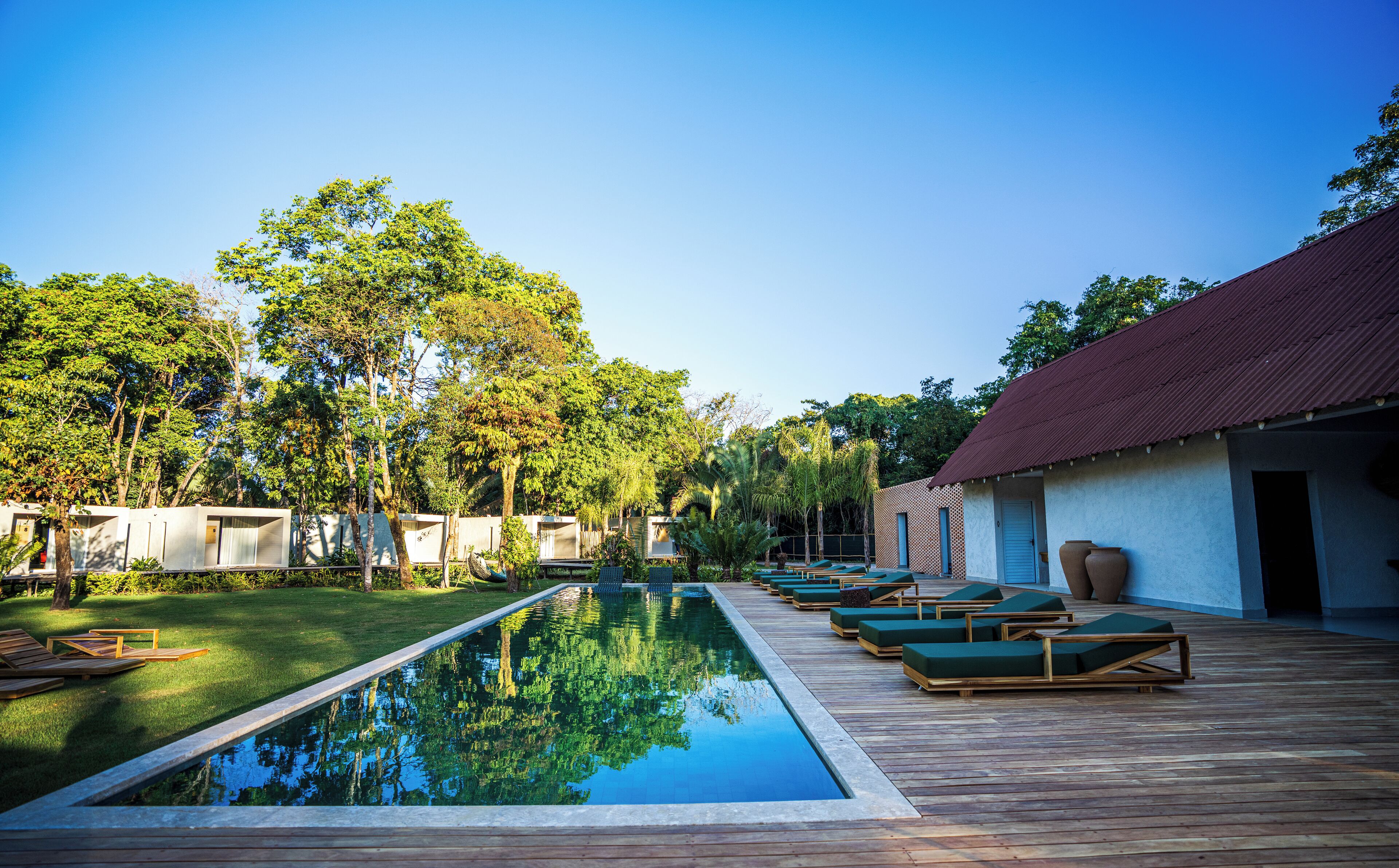 A pool area with lounge chairs and a wooden deck.