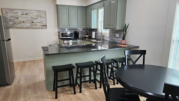 Une cuisine moderne avec un îlot central, des tabourets de bar et une table à manger.