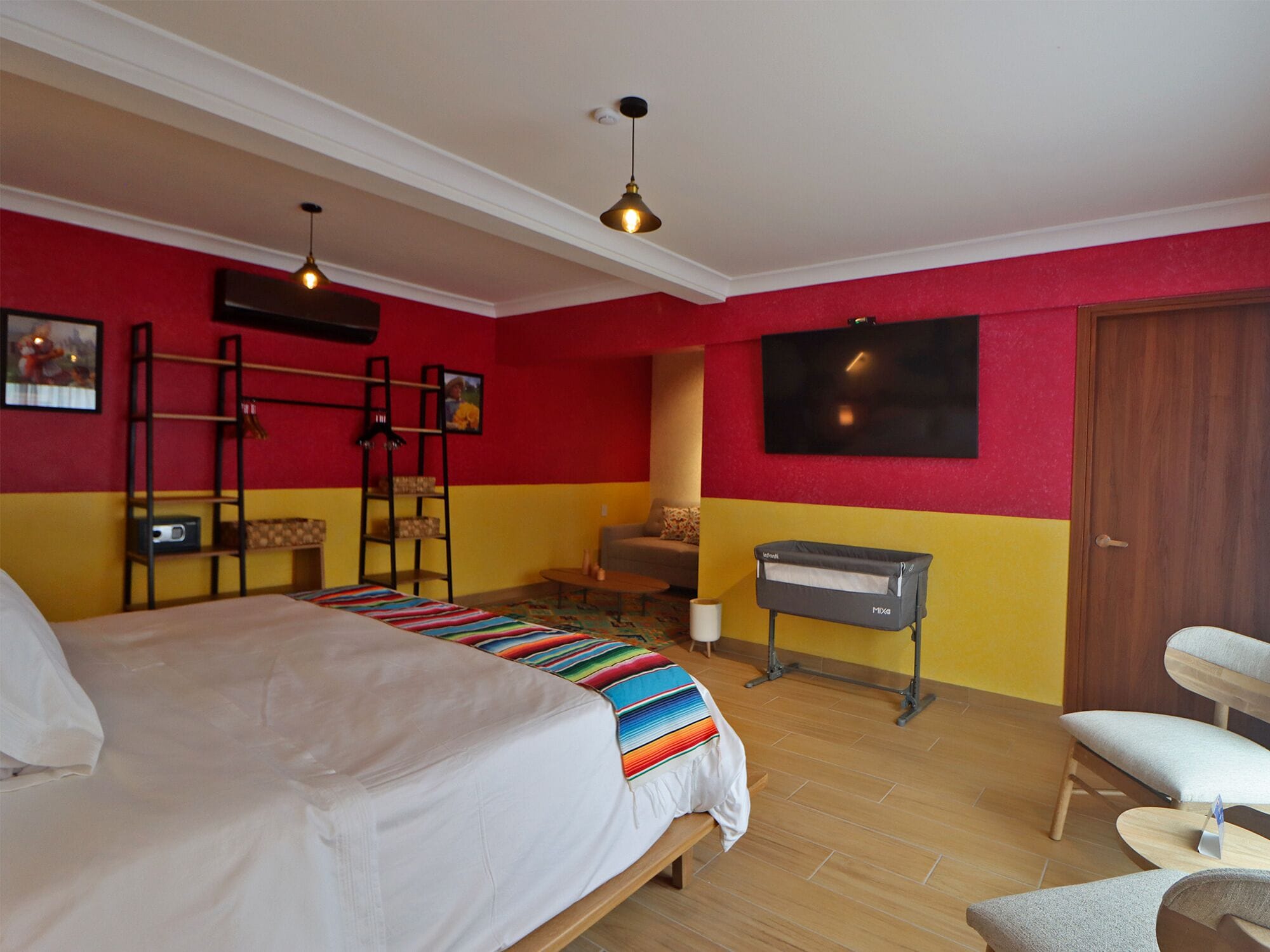 A bedroom with a bed, a TV, a desk, and a chair.