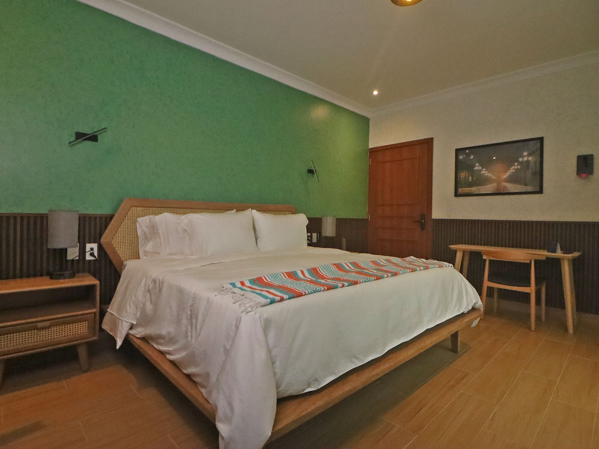 Ein Schlafzimmer mit einem Bett, einem Nachttisch, einem Tisch und einer Tür.