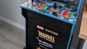 Una máquina recreativa de Marvel Super Heroes en una habitación con ventana.