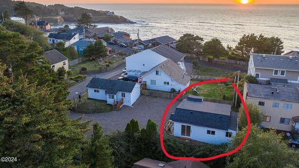 Zona residencial costera con casas y vista al atardecer.