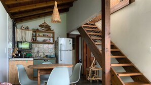 Eine gemütliche Küche mit Essbereich, einer Holztreppe und Blick zum Wohnzimmer.