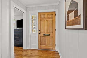 A hallway with a wooden door, a black dresser, and a framed picture on the wall. - 🐴🏠 CHARMING DOWNTOWN GEORGETOWN 3-bed/2-bath home. Professionally decorated. (Georgetown)