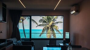 Ein Zimmer mit einem großen Fenster, einem Bett, einem Schreibtisch und einem Stuhl.